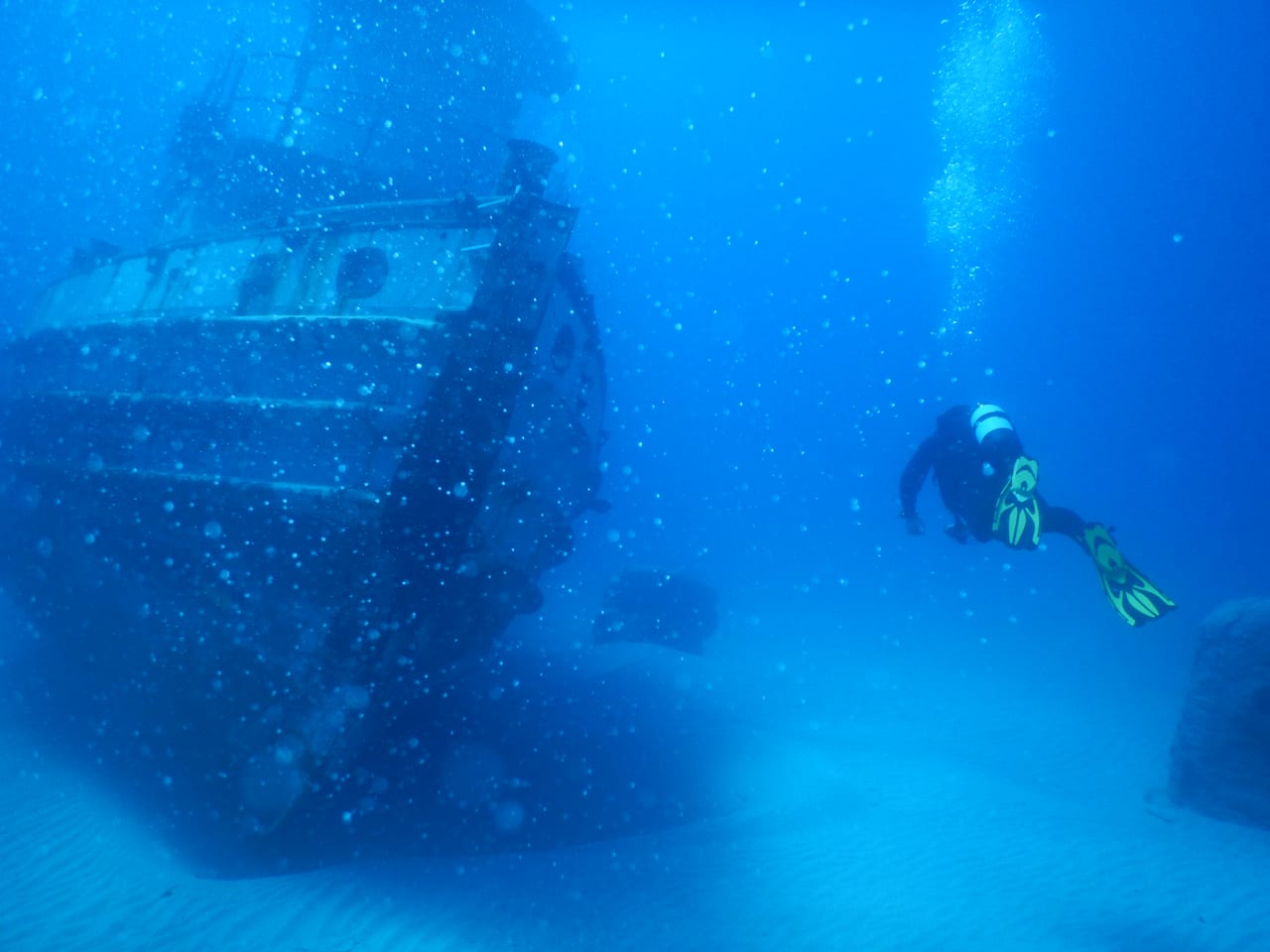 A diver over a Mediterranean reef in clear water